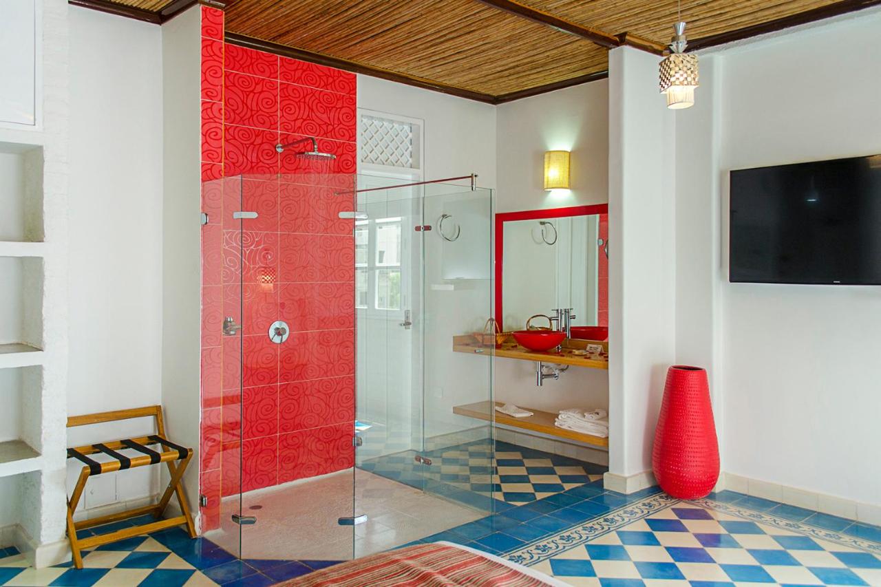 Uguana Nuka, ducha de cristal y lavamanos rojo